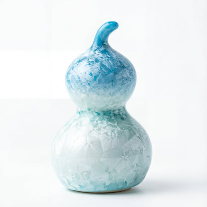 A small ceramic gourd with a pale icy blue crystalline glaze texture.