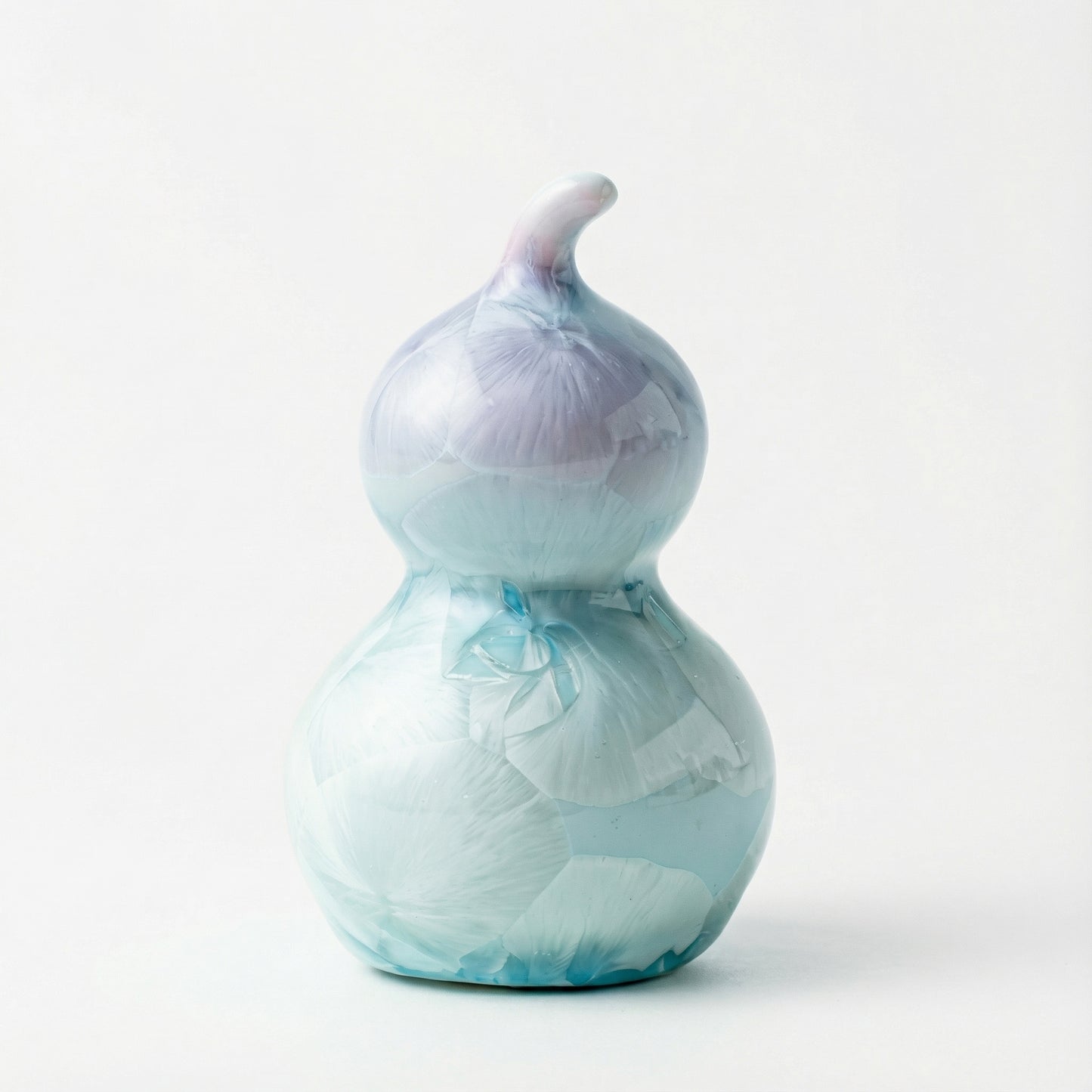 A small ceramic gourd with a soft lavender purple crystalline glaze.