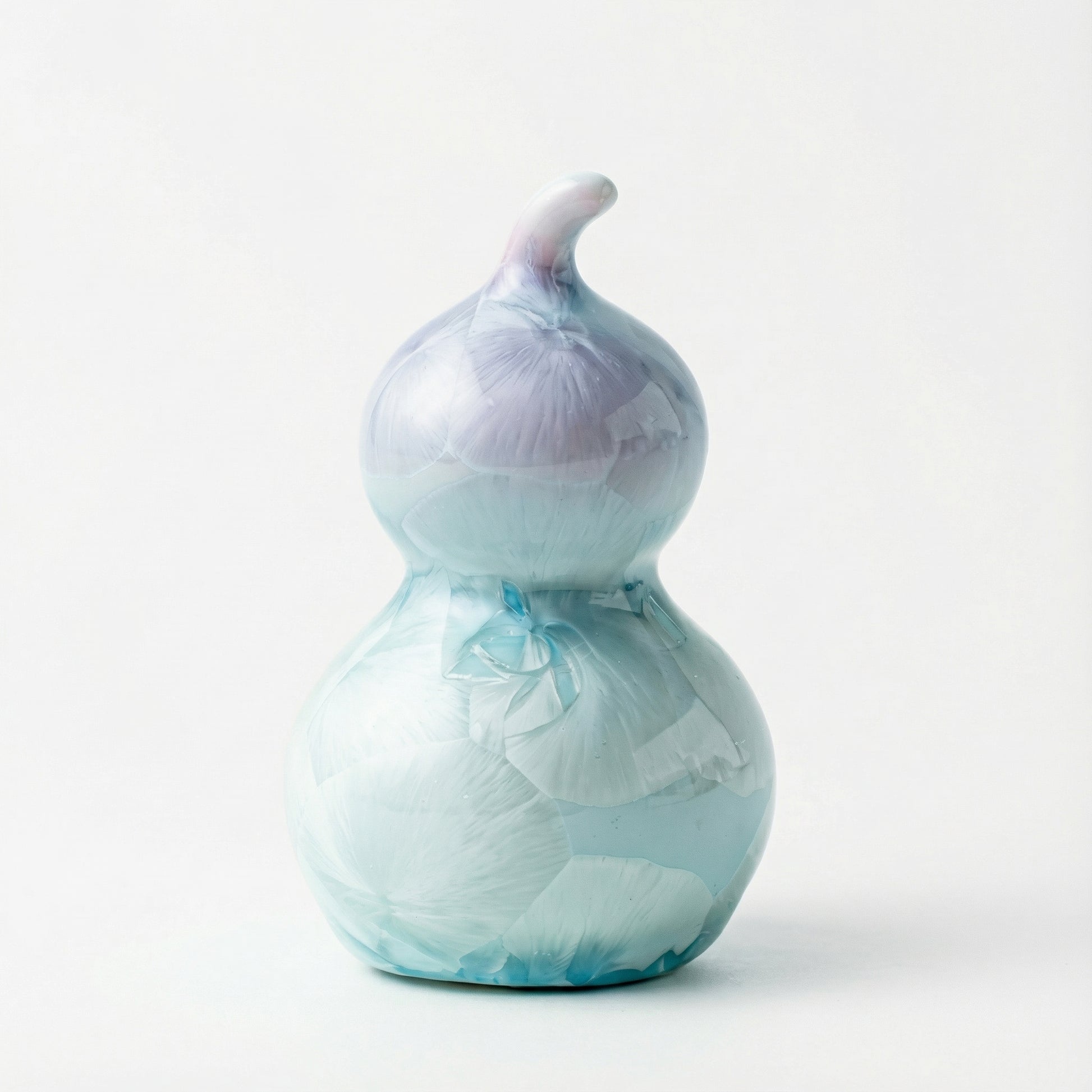 A small ceramic gourd with a soft lavender purple crystalline glaze.