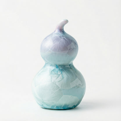 A small ceramic gourd with a soft lavender purple crystalline glaze.