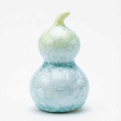 A small ceramic gourd with a pale lime green crystalline glaze
