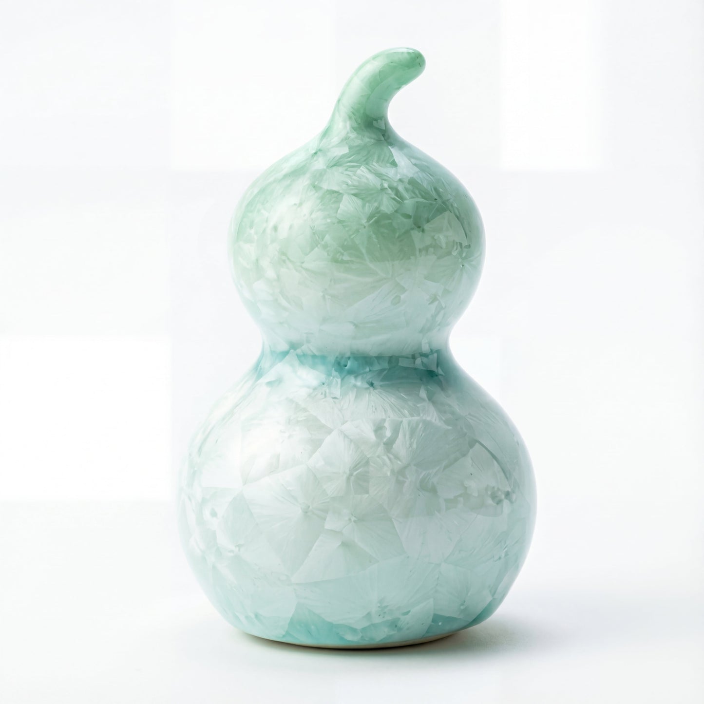 A small ceramic gourd featuring a fresh mint green or turquoise crystalline glaze
