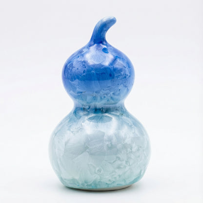 A small ceramic gourd featuring a deep royal blue crystalline glaze with frost-like patterns.