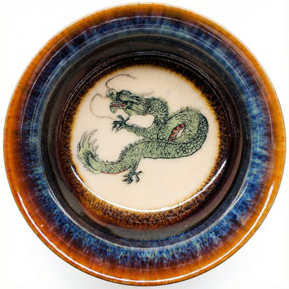 Handmade ceramic tea bowl featuring a hand-painted green dragon and blue glaze finish.