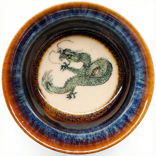 Handmade ceramic tea bowl featuring a hand-painted green dragon and blue glaze finish.