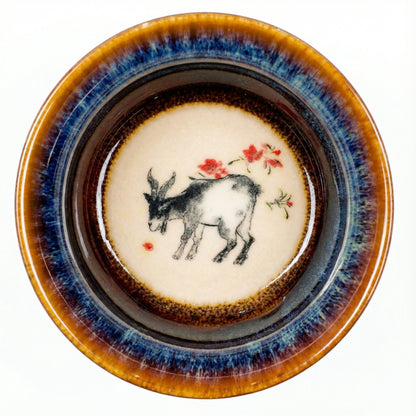 Elegant ceramic tea cup with a peaceful Goat motif, handcrafted with distinct glaze patterns.