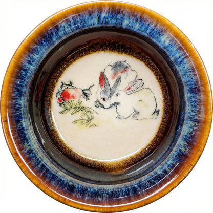 Delicate ceramic tea bowl with a gentle Rabbit design and artistic glaze texture.