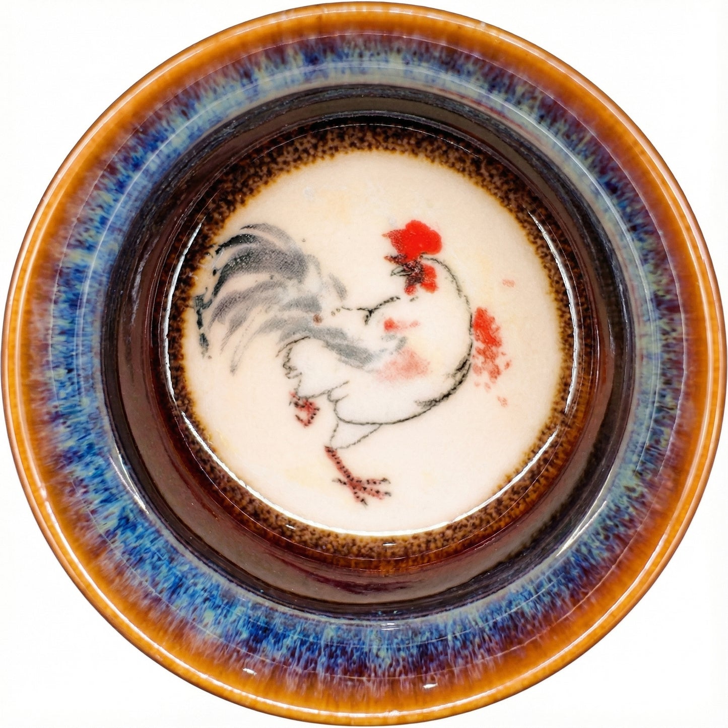 Colorful ceramic tea cup featuring a proud Rooster design and rustic kiln-fired aesthetics.